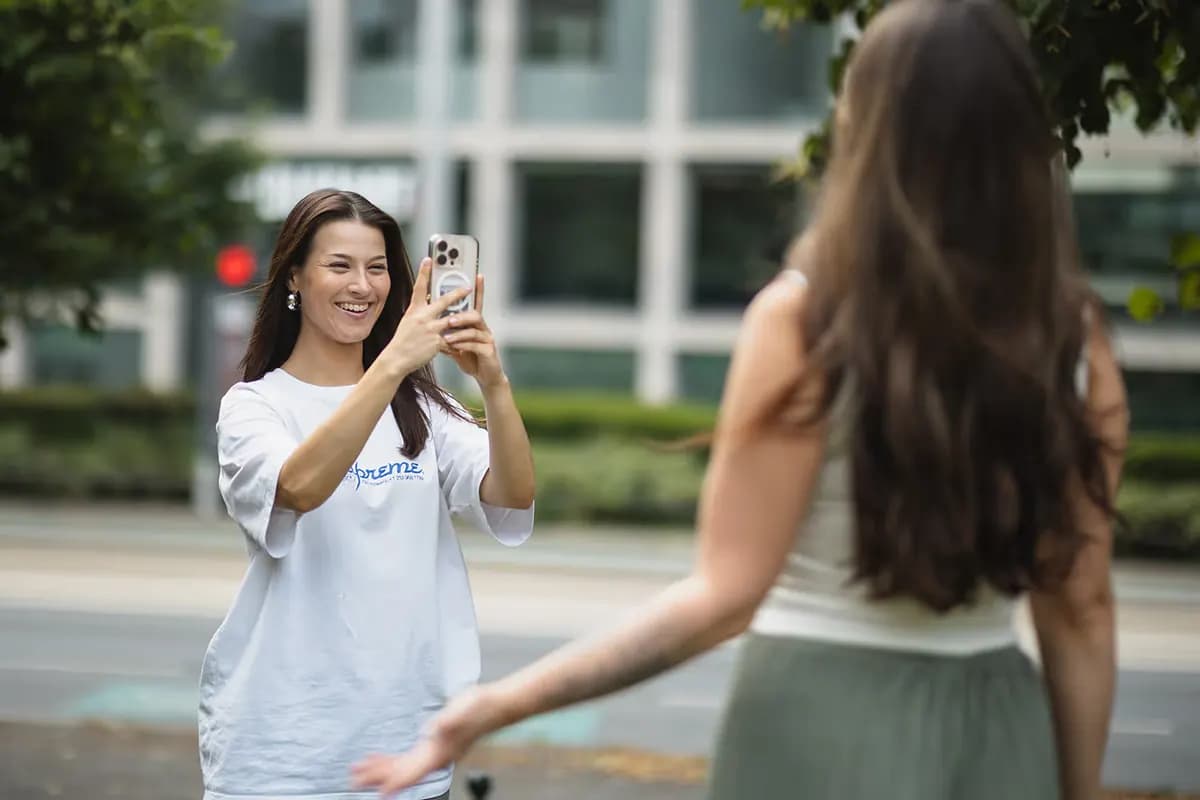 Eine Frau nimmt mit einem Smartphone ein kurzes Video auf.