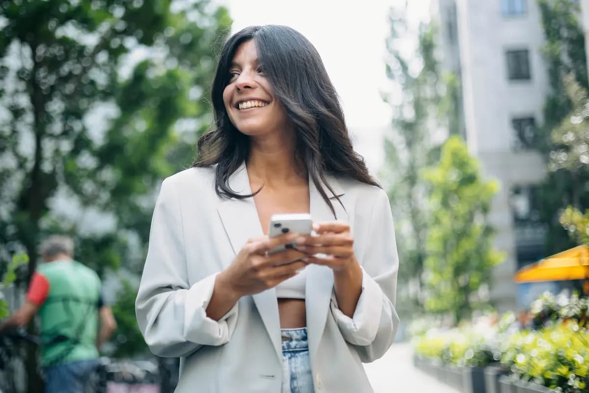 Eine Frau nutzt im Freien ein Smartphone.