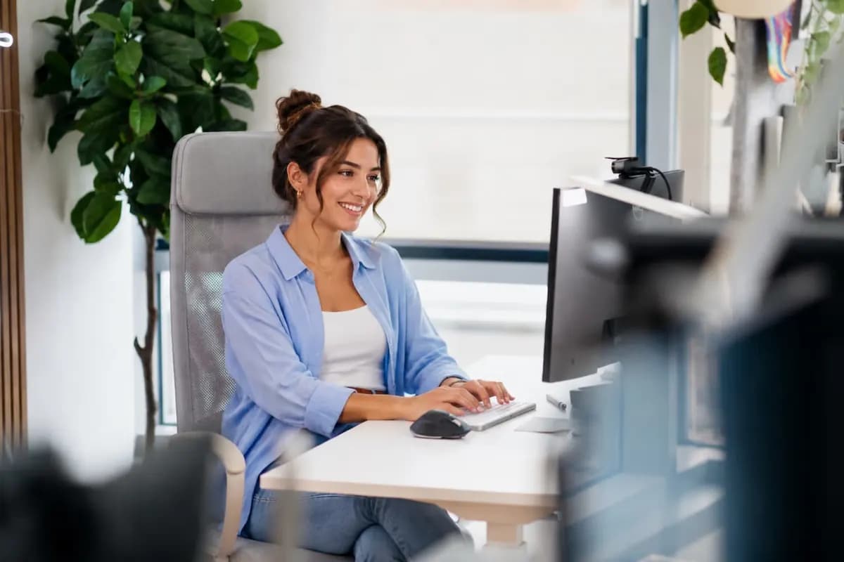 Eine Frau arbeitet an einem Desktop-Computer.